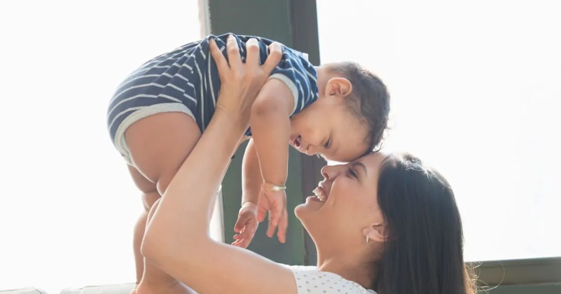 Person holds infant in arms