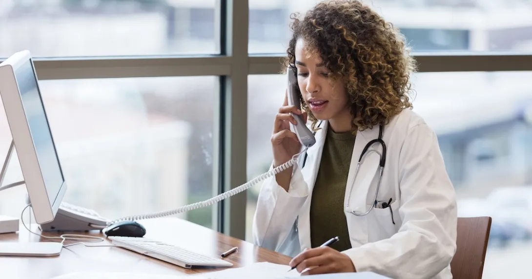 Healthcare professional talking to someone on the phone Healthcare professional talking to someone on the phone
